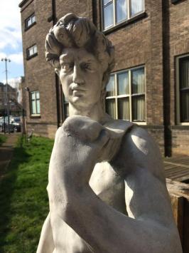 Groot beeld vol steen van de Bijbelse figuur David op sokkel