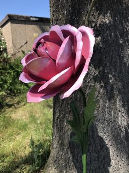 Ein Kunstwerk, große rosa Rose aus Metall, auf Stiel