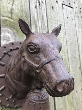 Deurbel met paardenhoofd gevestigd op een fraaie achtergrond