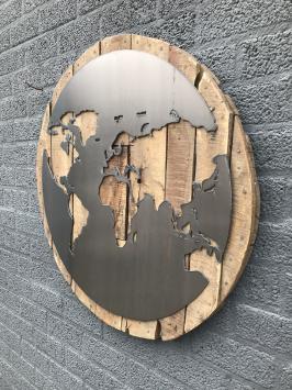 Großes Wandornament aus Holz mit einer Welt darauf, ein Meer aus Metall